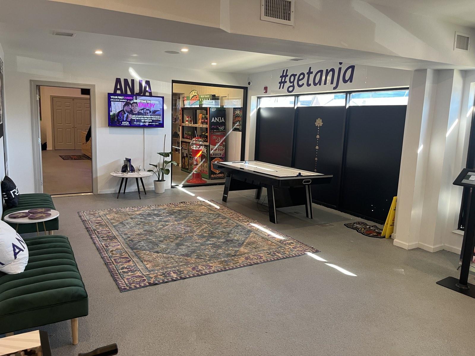 Lounge area with seating and air hockey table inside the ANJA dispensary